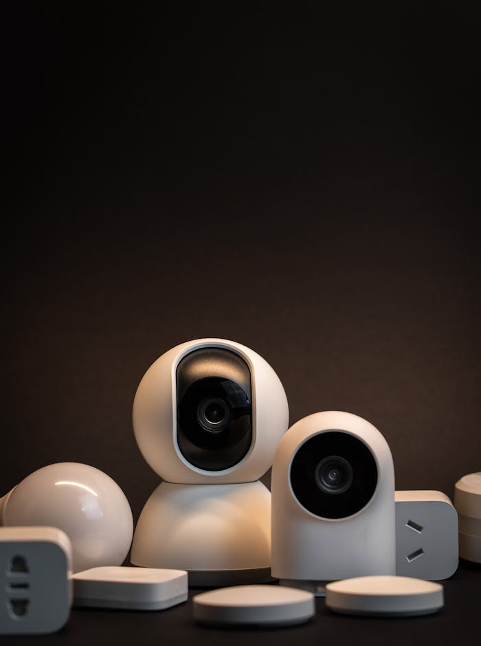 Accueil Close-up of modern white security cameras and smart home devices with dark background.